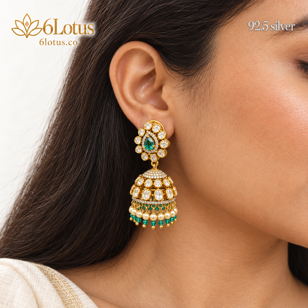 Close-up of 1002 green jhumka earring worn on the ear